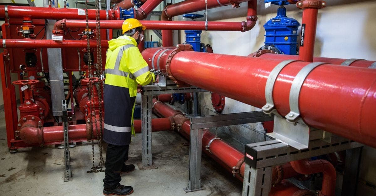 Licensed plumber checking toilet water supply connection before installation